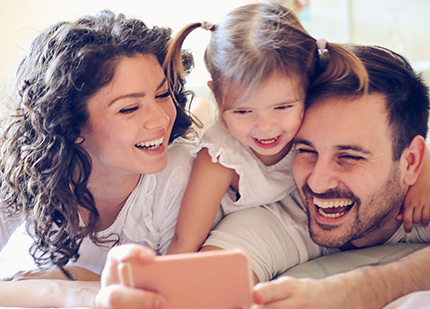 family laughing while looking at phone