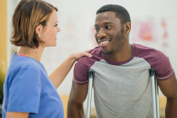 doctor helping man on crutches