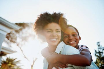 woman holding son on her back