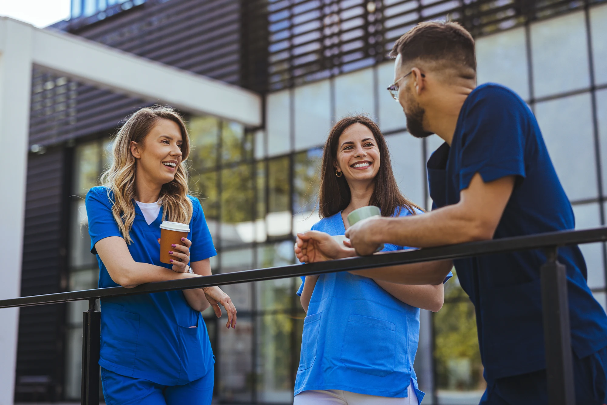 Medical students socializing outside while holding coffee cups
