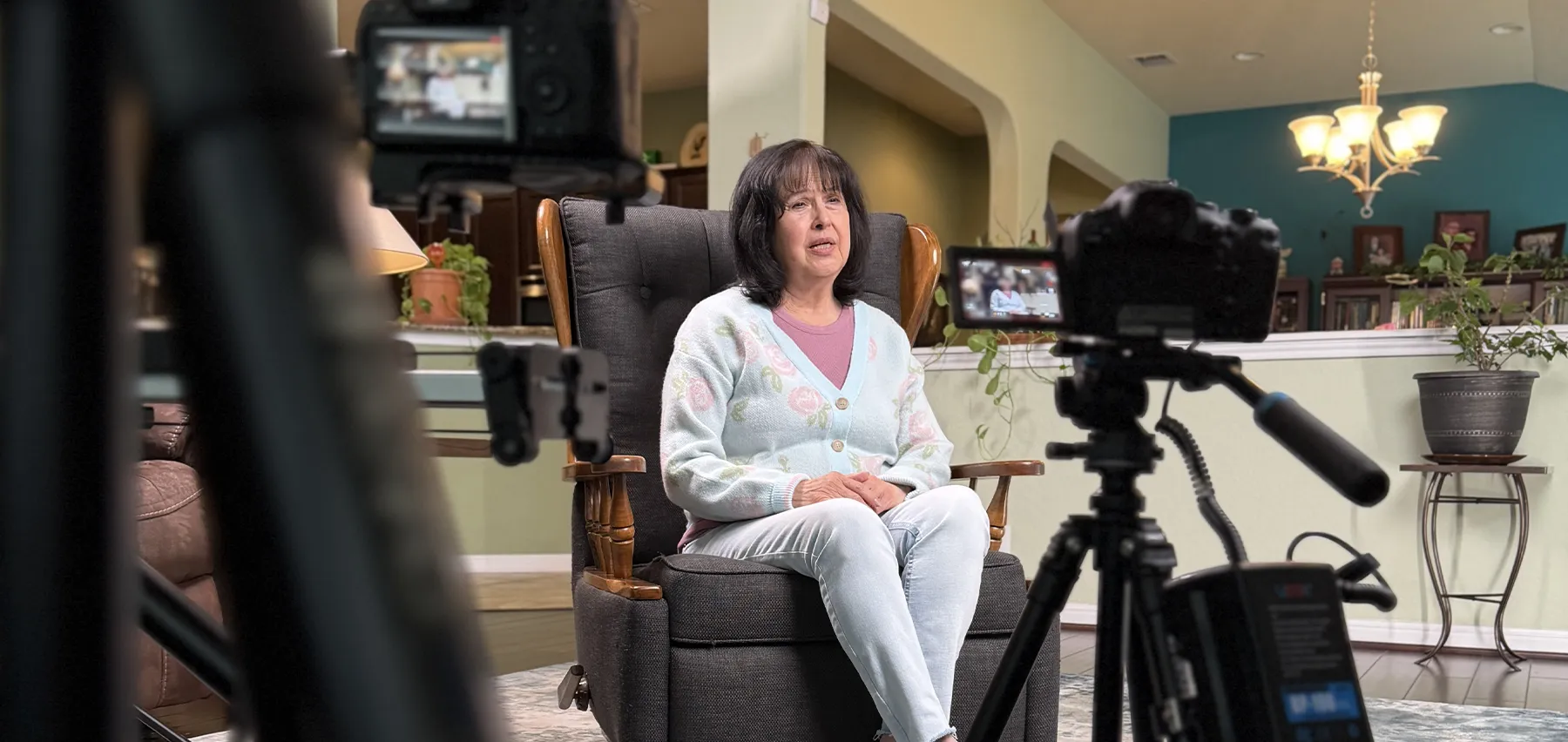 Linda looks into a video camera while recording her story.