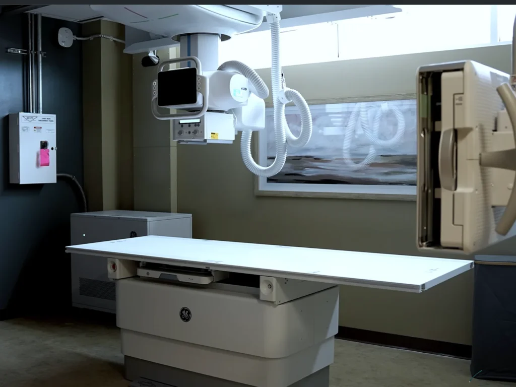 X-ray room with imaging table and overhead diagnostic equipment
