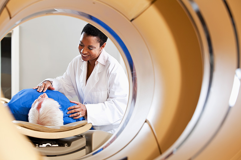 A Tech helps an elderly man with his scan
